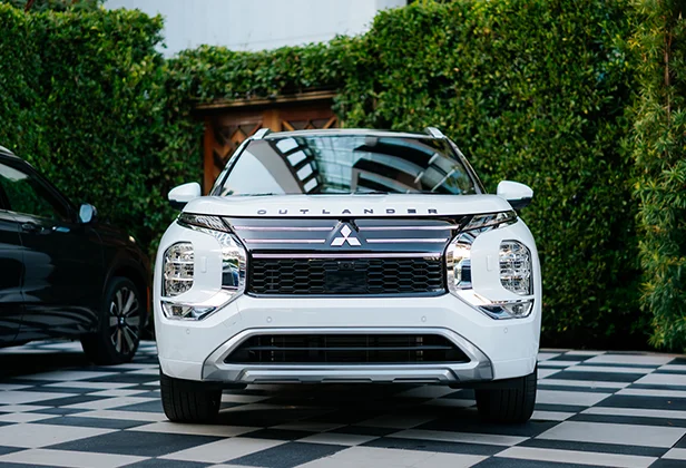 Front view of a white mitsubishi vehicle parked on a checkered floor