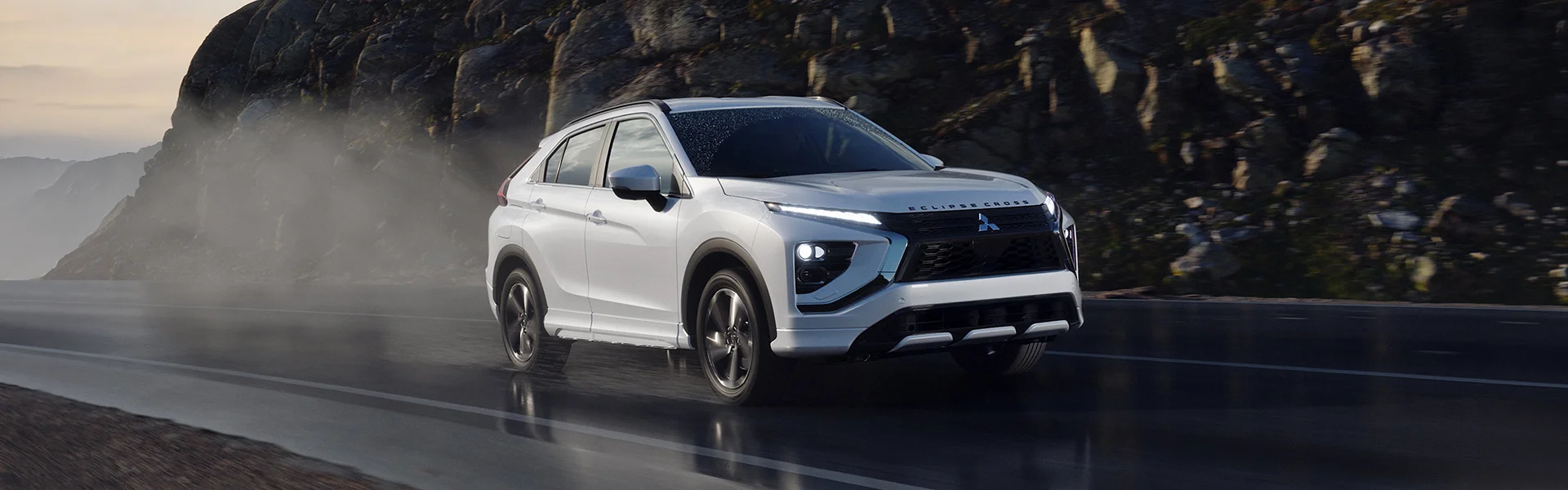 Mitsubishi Driving by a tall rock side wall
