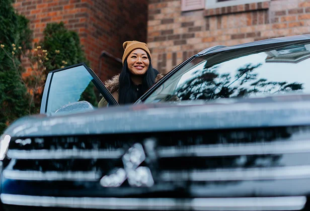 Smiling Woman stepping into a Mitsubishi